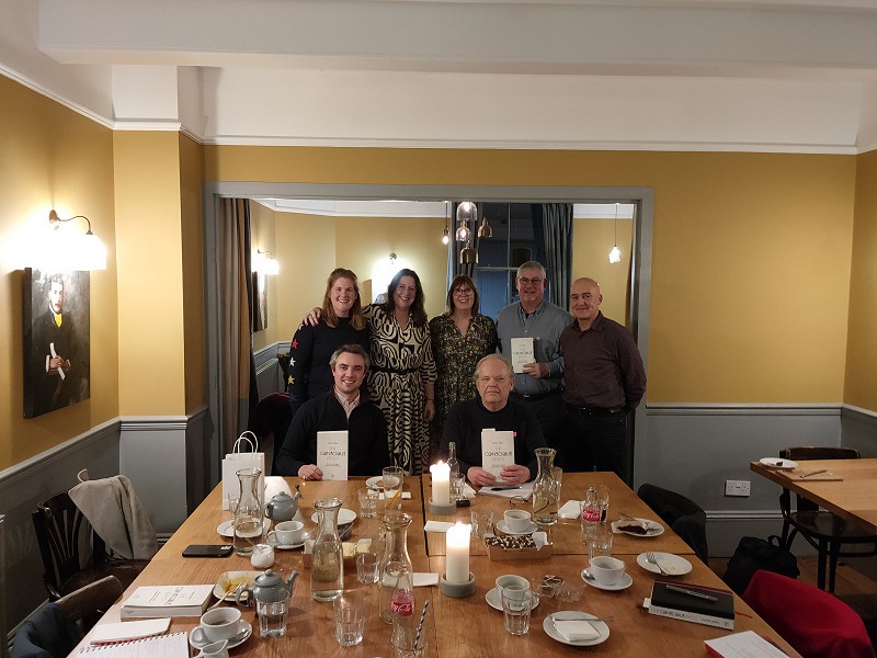 All the attendees gathered at the end of the table for a photo
